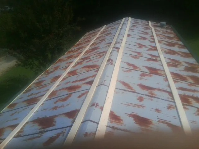 Rusted metal roof panels with new wood purlins before replacement — Storm Damage Roof Repair in Blodgett by Roofing Brothers