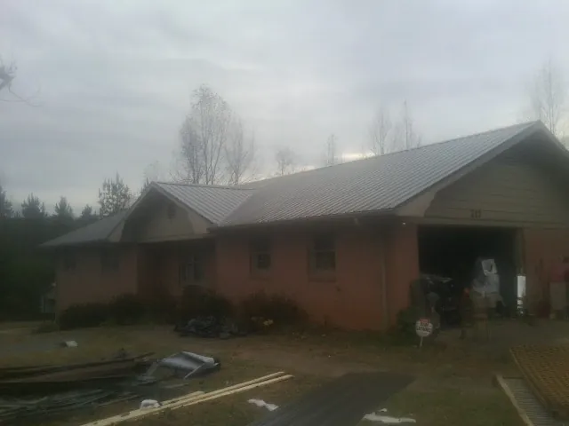 Gray metal roof on a stucco house with an attached garage in Blodgett